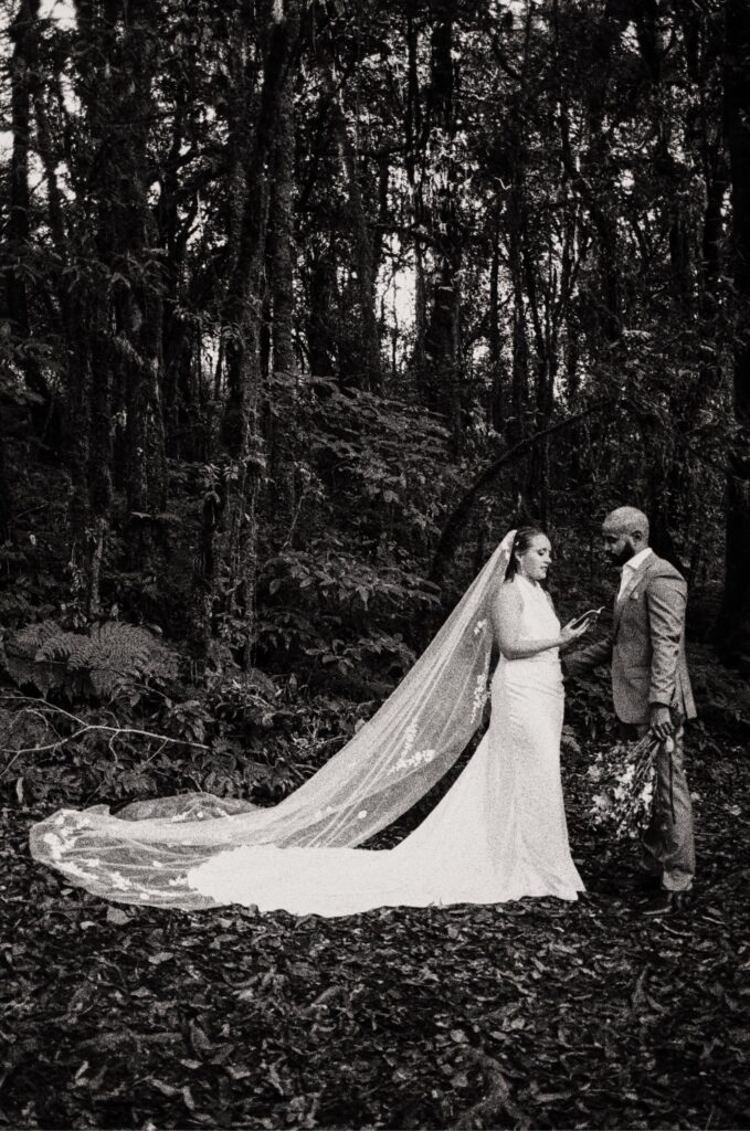 Bride and groom exchange vows in the forest during their destination elopement in Thailand, captured on black and white 35mm film by wedding film photographer