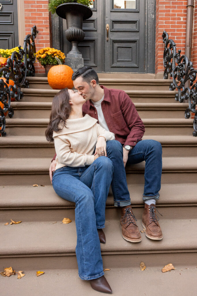 man and woman sit on stairs in South End Boston engagement photo shoot