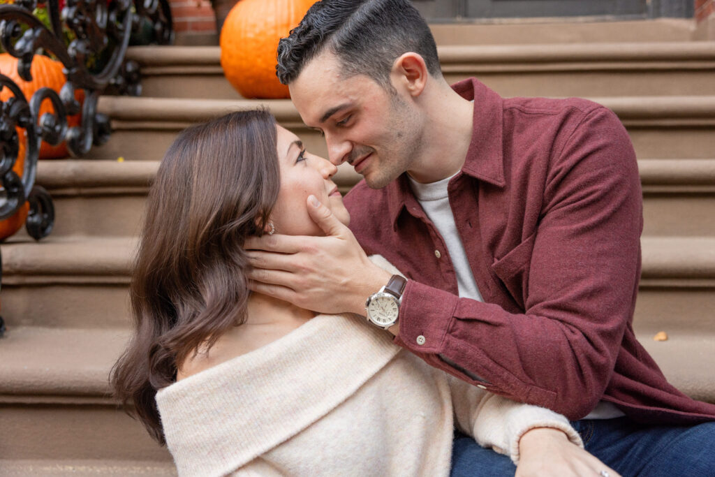 man and woman sit on stairs in South End Boston engagement photo shoot