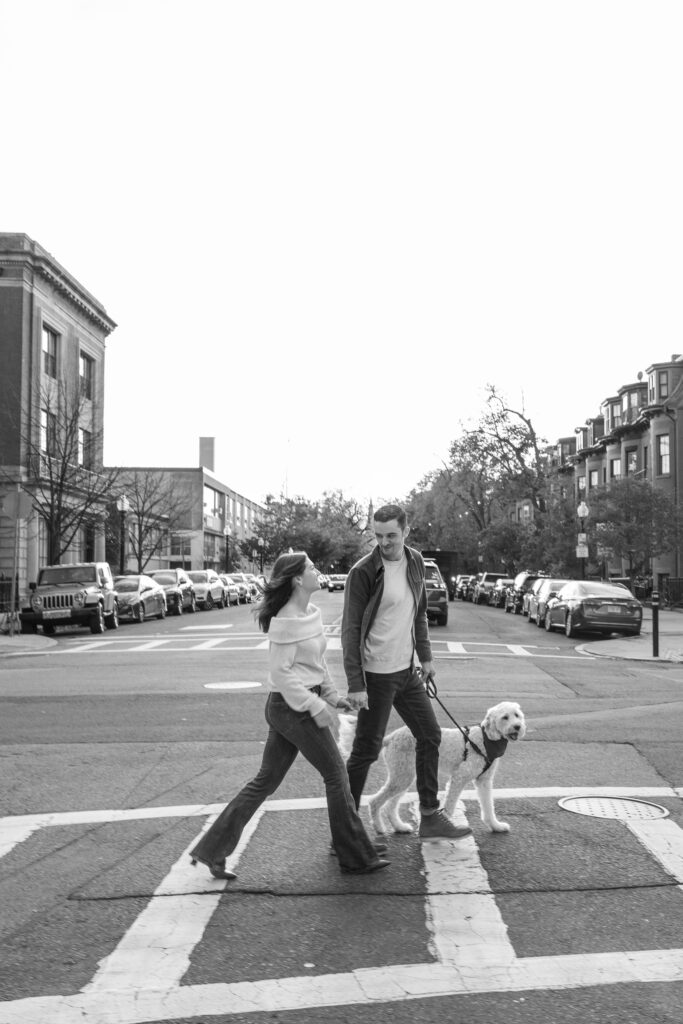 man and woman with golden doodle walk on South End street, Boston engagement photographer 