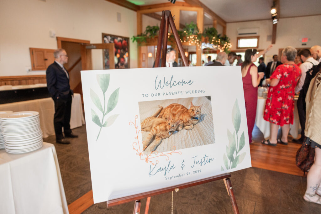 Welcome sign for wedding with bride and groom’s two cats on it