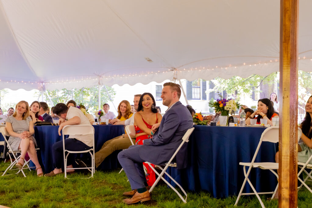 Candid moments of the Bride and groom with the rest of their guests listening to the wedding speeches being made at their wedding at the Loring-Greenough House