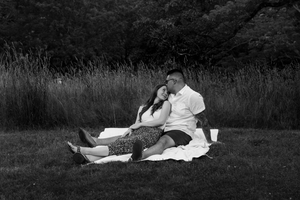 Engaged couple session at the Arnold Arboretum. Diverse Couple, engaged mixed couple sitting down in front of a wheat field In Candid moments black and white
