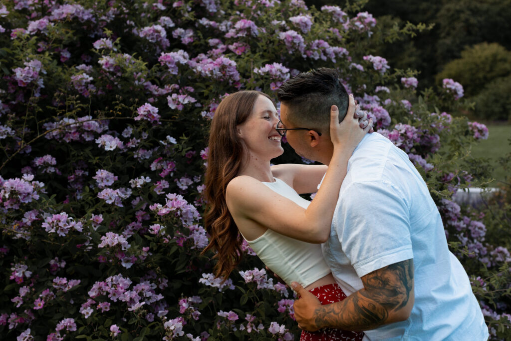 Engaged couple session at the Arnold Arboretum. Diverse Couple, engaged mixed couple, Candid moments of the couple leaning in for a kiss