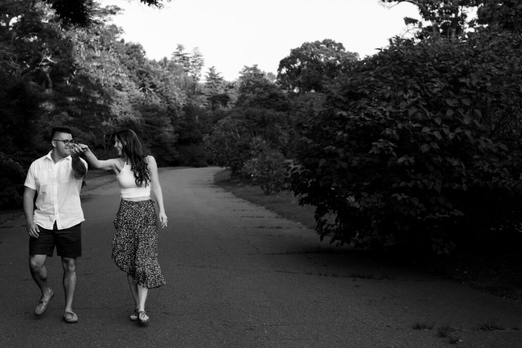 Engaged couple session at the Arnold Arboretum. Diverse Couple, engaged mixed couple, Candid moments of the couple walking together holding hands in black and white
