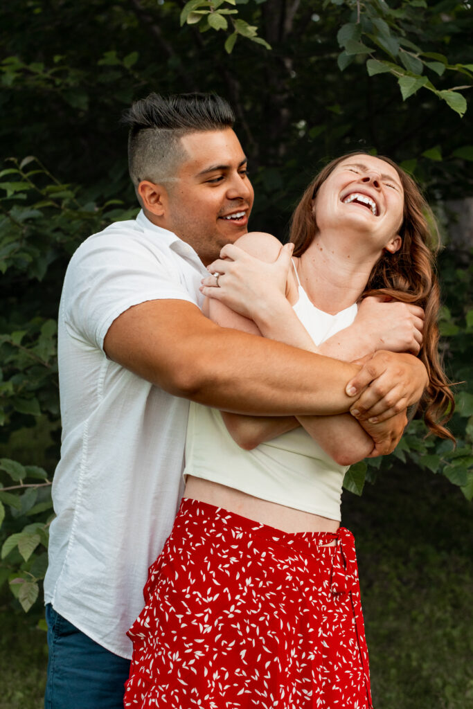 Engaged couple session at the Arnold Arboretum. Diverse Couple, engaged mixed couple, Candid moments of the couple hugging each other and having a laugh