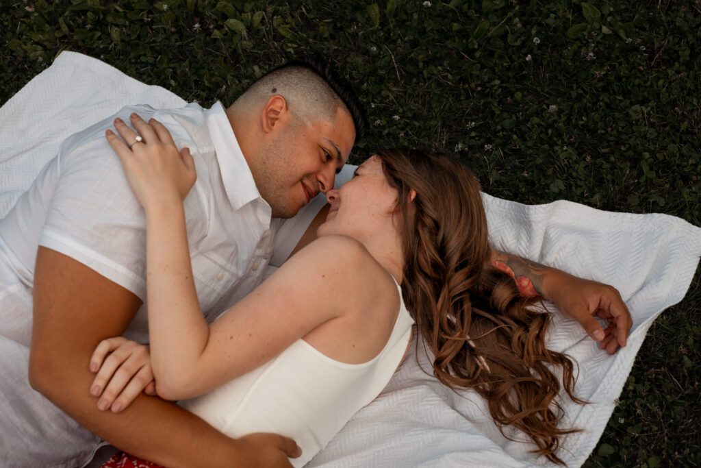 Engaged couple session at the Arnold Arboretum. Diverse Couple, engaged mixed couple, Candid moments of the couple overhead photo of them laying down on a blanket