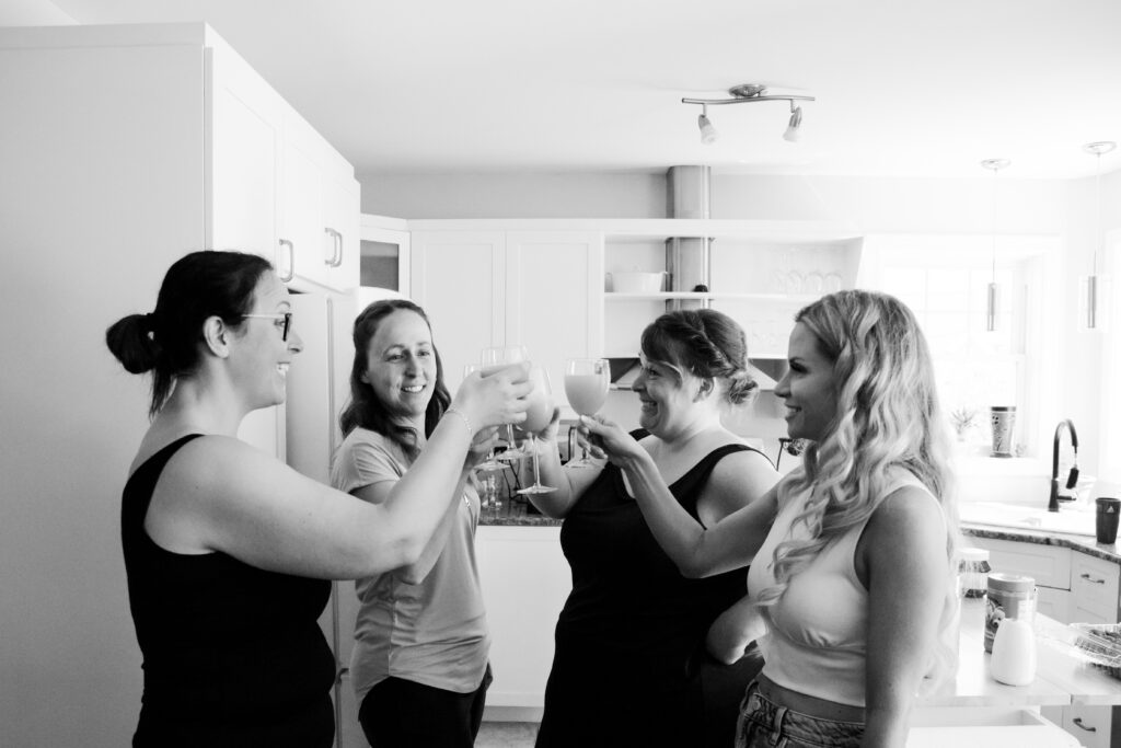 Bride with her bridesmaids toasting with mimosas