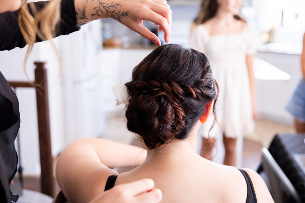The bride gets her hair done in an updo in the bridal suite