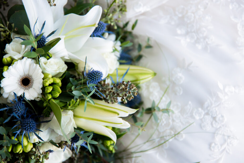 Detail photo of the wedding bouquet with white, green, and blue florals