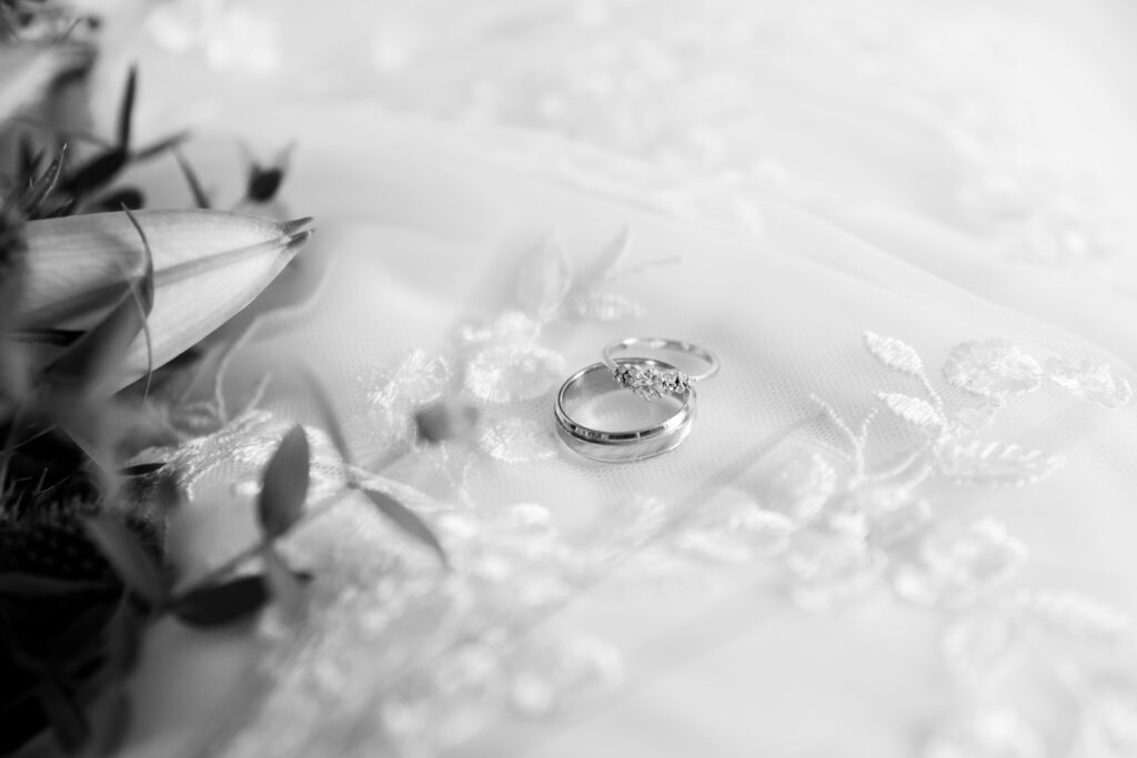 Detail photo of wedding rings, Wedding bands and engagement band with wedding bouquet in black and white