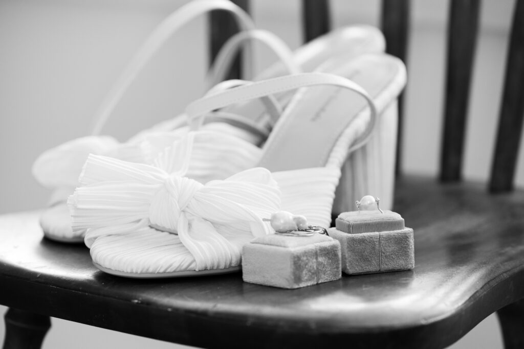 Detail shot , Black and White photo bridal shoes and ring box with pearl ring