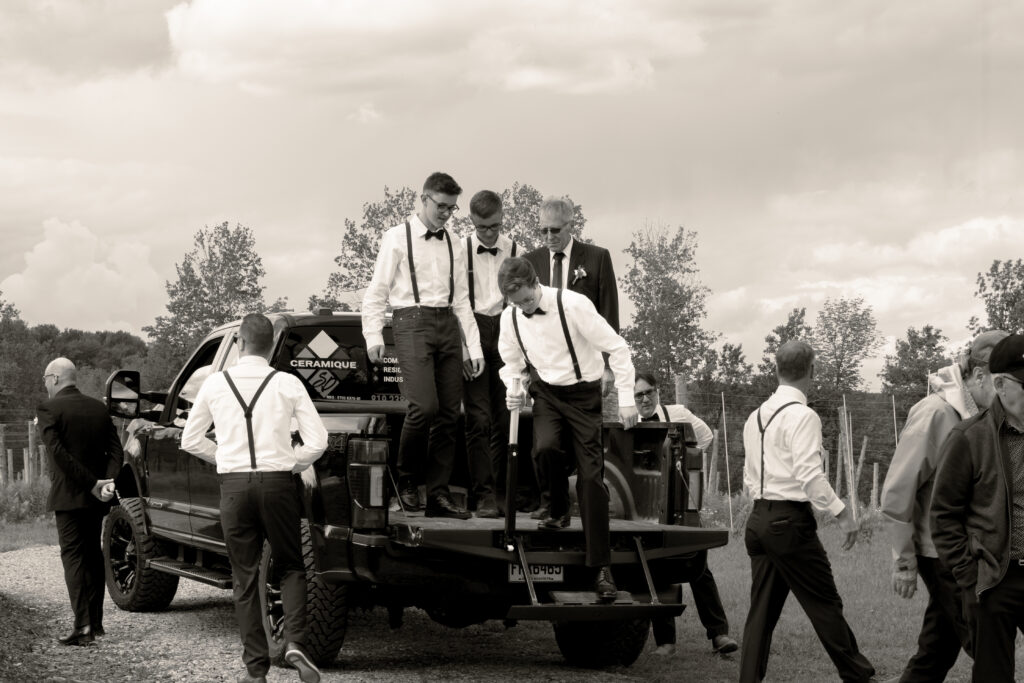 Groomsmen getting of the back of the truck at the wedding venue