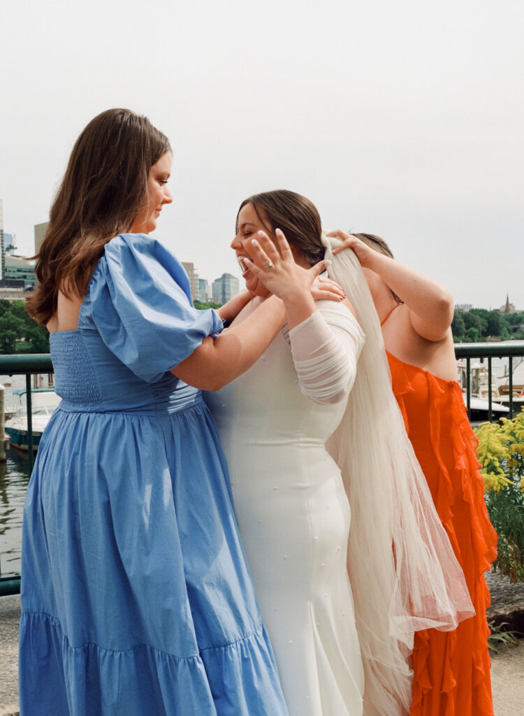 Bridesmaids help bride with her veil before a queer wedding celebration in Cambridge, captured on film by Boston-based queer wedding film photographer