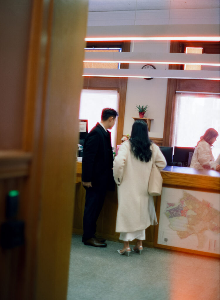Documentary-style image of the couple waiting outside the clerk’s office inside Cambridge City Hall, taken on film.