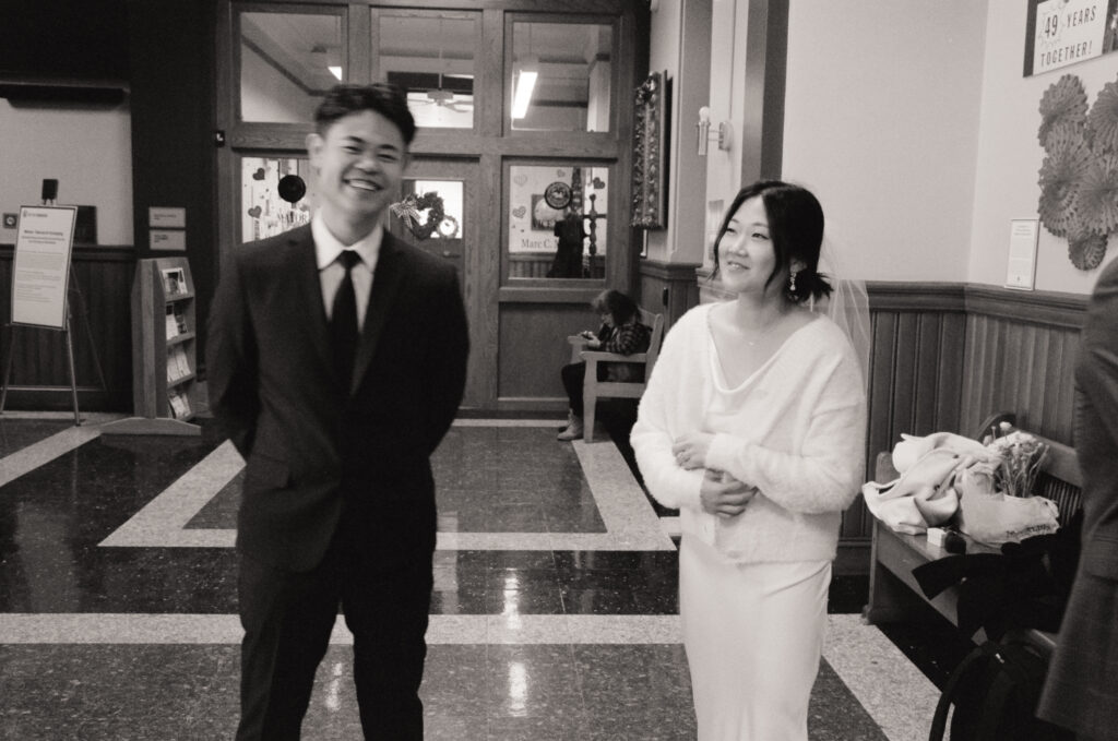 Documentary-style image of the couple waiting outside the clerk’s office inside Cambridge City Hall, taken on 35mm film.