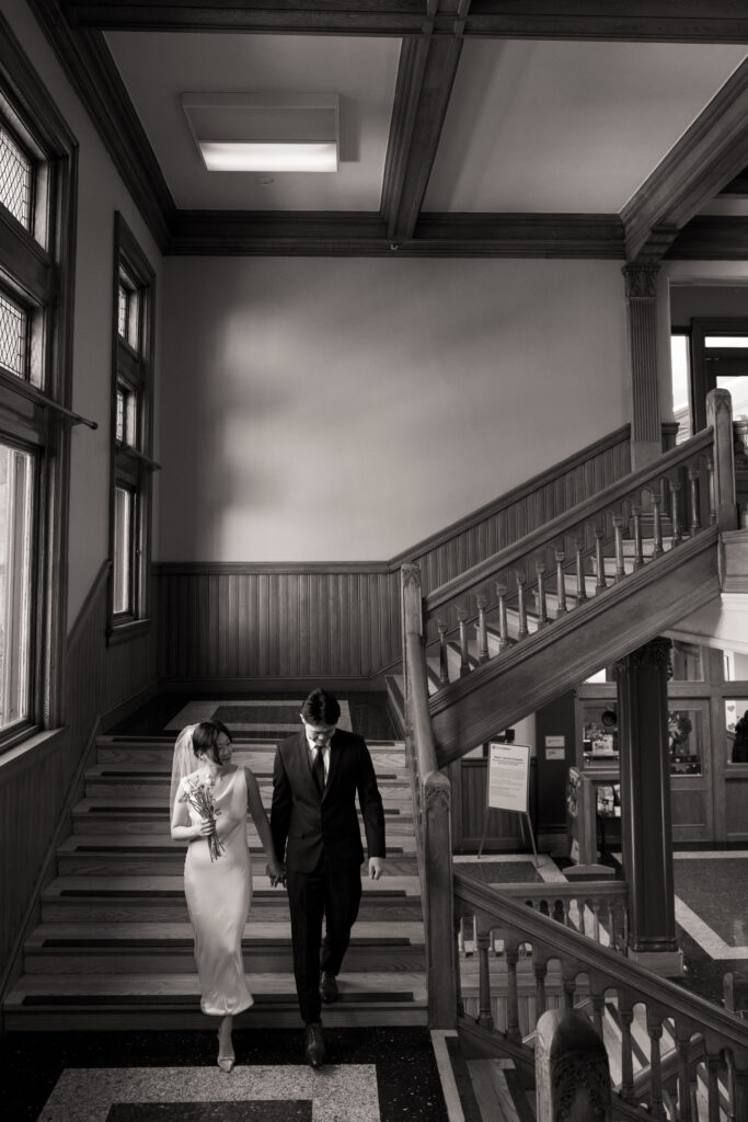 Natural film portrait of the couple walking through Cambridge City Hall before their elopement, full of warmth and anticipation.