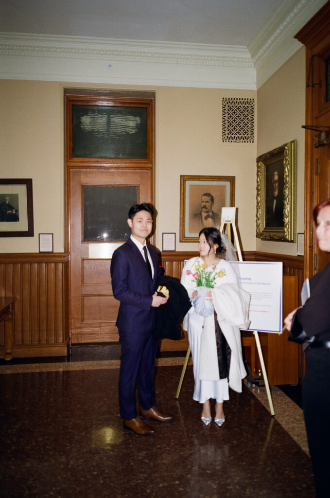 Group portrait of newlyweds Anna and Huimin with both families before their Cambridge City Hall ceremony, captured by a Boston film elopement photographer.