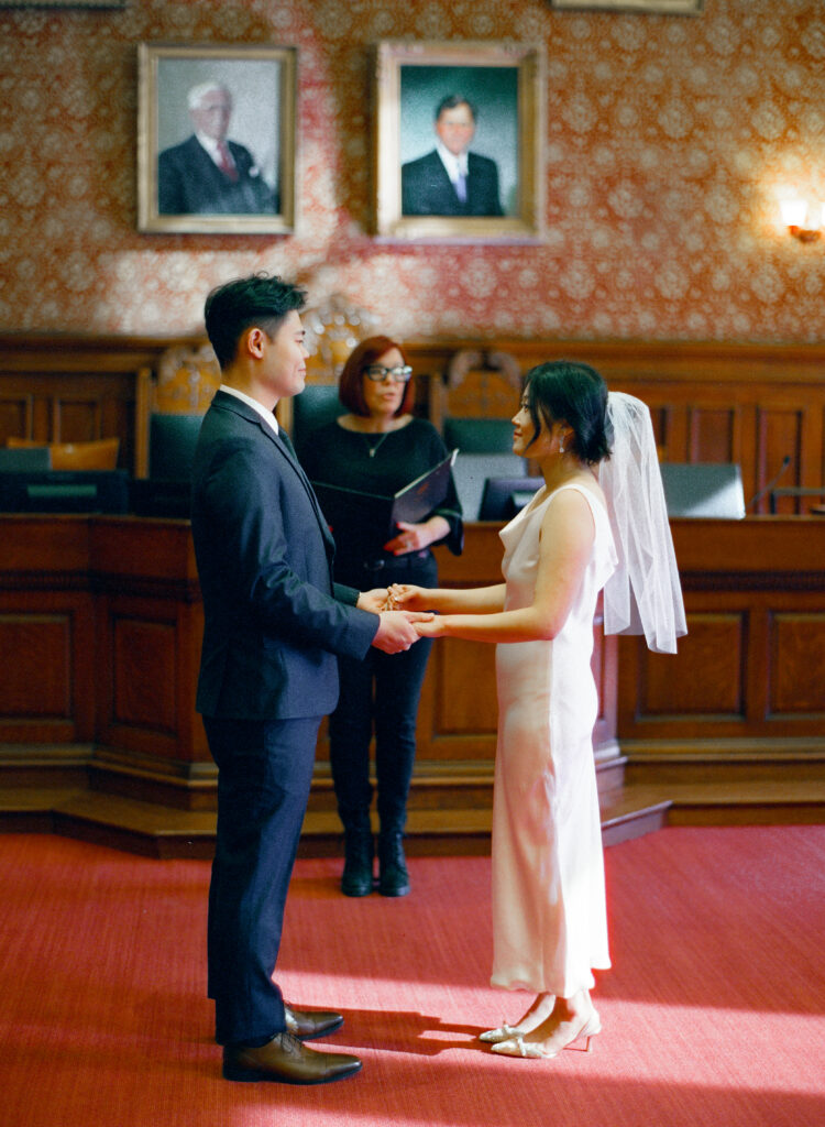 Couple exchanging vows during their Cambridge City Hall elopement ceremony, captured on 35mm film.
