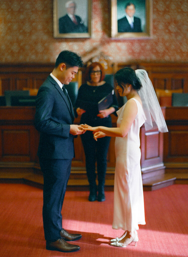 Bride and groom smiling during their elopement ceremony at Cambridge City Hall, photographed on film.