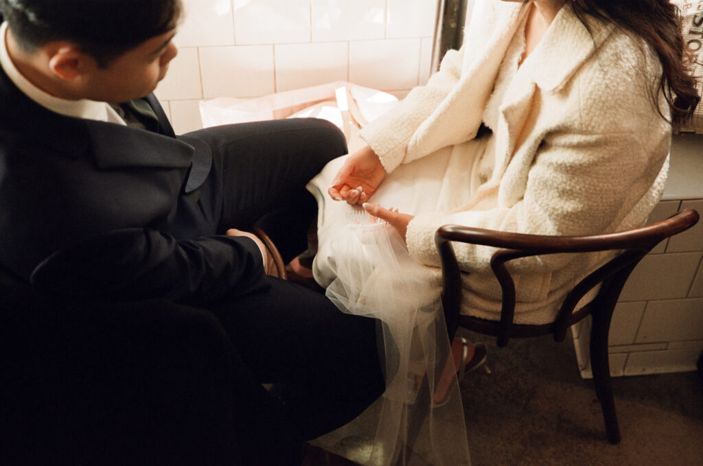 Couple enjoying coffee and pastries together after their Cambridge elopement on film.