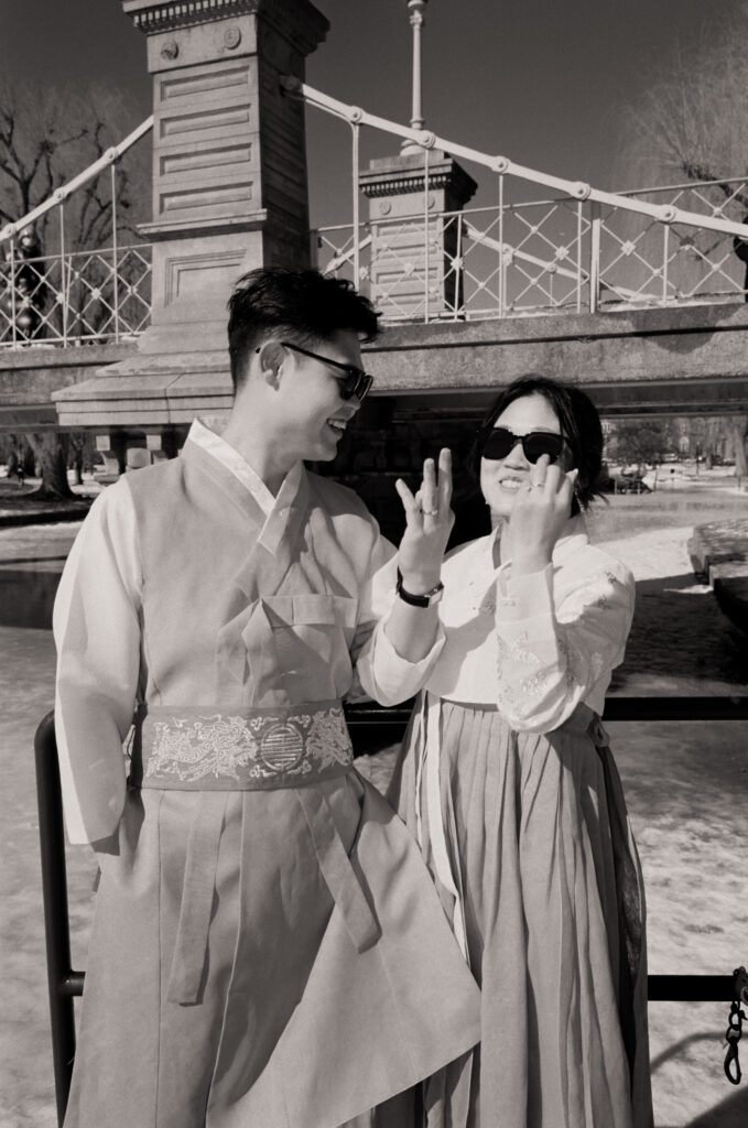 Couple laughing near frozen pond in Boston Public Garden during winter elopement.