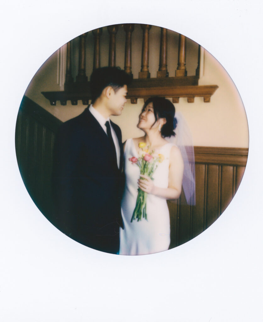 Polaroid photo of Anna and Huimin laughing together in the hallway of Cambridge City Hall after their elopement ceremony, captured on film.
