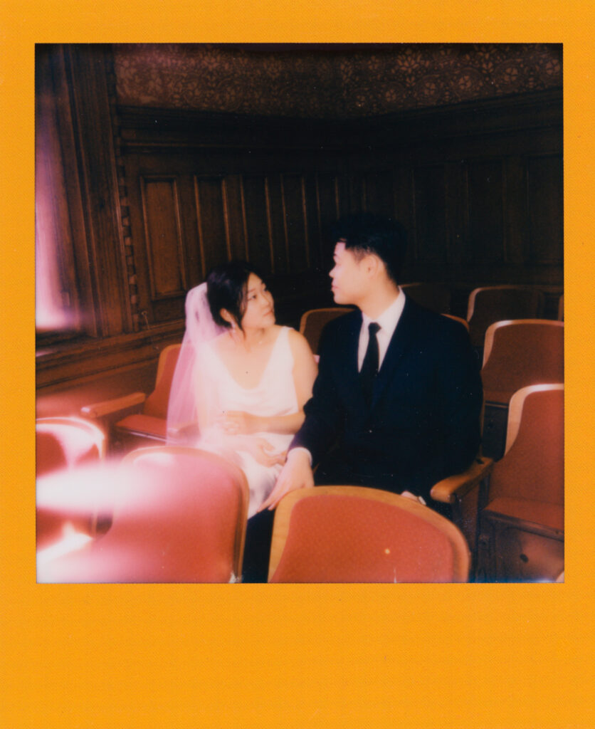 Polaroid photo of newlyweds Anna and Huimin sitting together inside Cambridge City Hall, moments after their elopement ceremony—captured on film by a Boston elopement photographer.