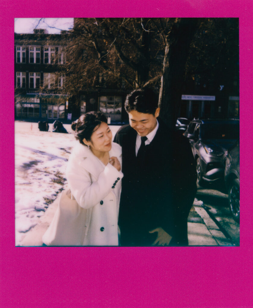 Bride and groom smiling and exiting Cambridge City Hall after their elopement, photographed on instant film / polaroid