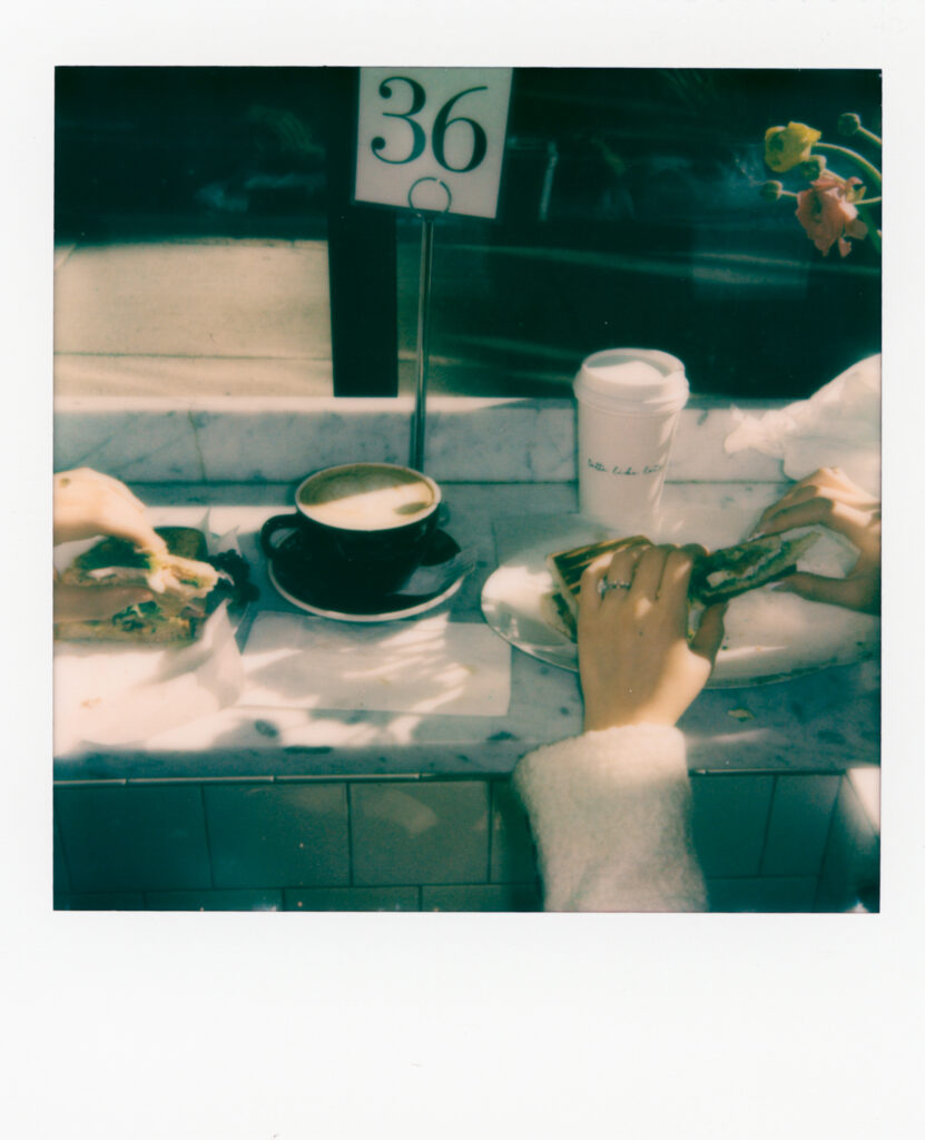Couple enjoying coffee and pastries together after their Cambridge elopement on polaroid