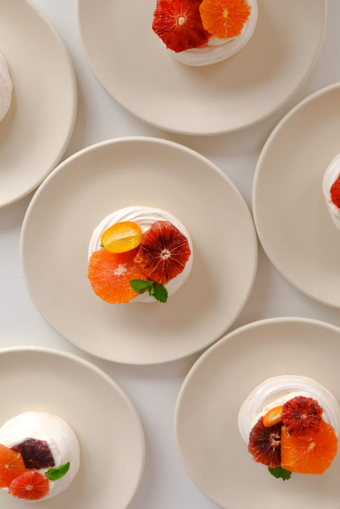 Modern citrus wedding dessert inspiration featuring blood orange pavlovas with kumquat and mint garnish. Perfect for spring weddings or colorful wedding dessert tables. Captured on film by a Boston-based film wedding photographer.