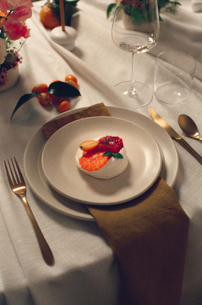 Elegant citrus-inspired wedding dessert idea featuring a blood orange pavlova on minimalist stoneware. A modern spring reception detail captured on film by a New England film wedding photographer.