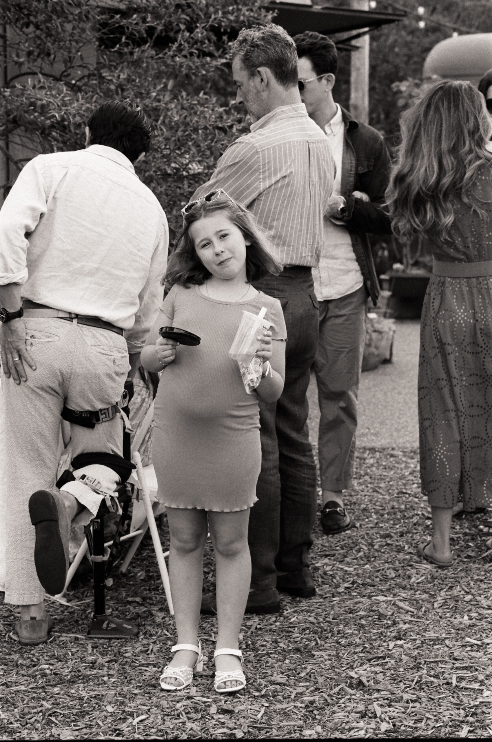 Young guest smiling with a drink in hand during rehearsal dinner at Noman’s, Martha’s Vineyard wedding weekend.
