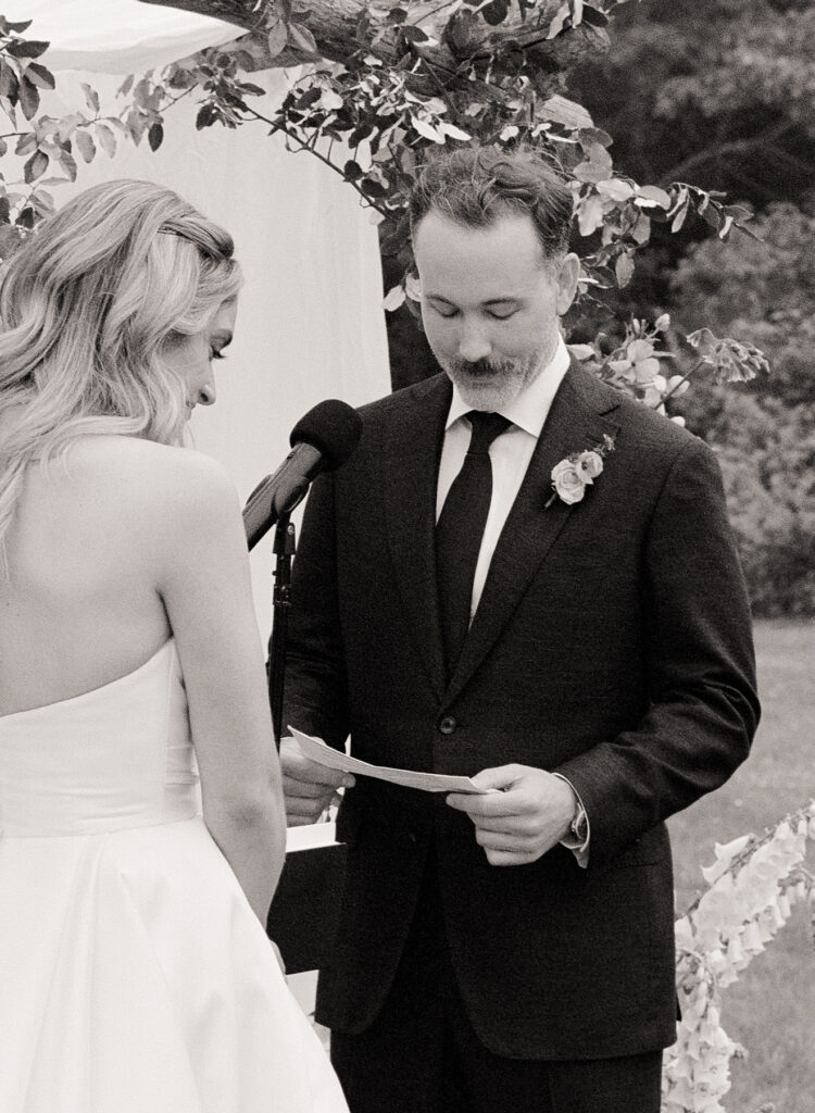 Groom reading vows at outdoor wedding ceremony – black and white Martha's Vineyard film wedding photography.