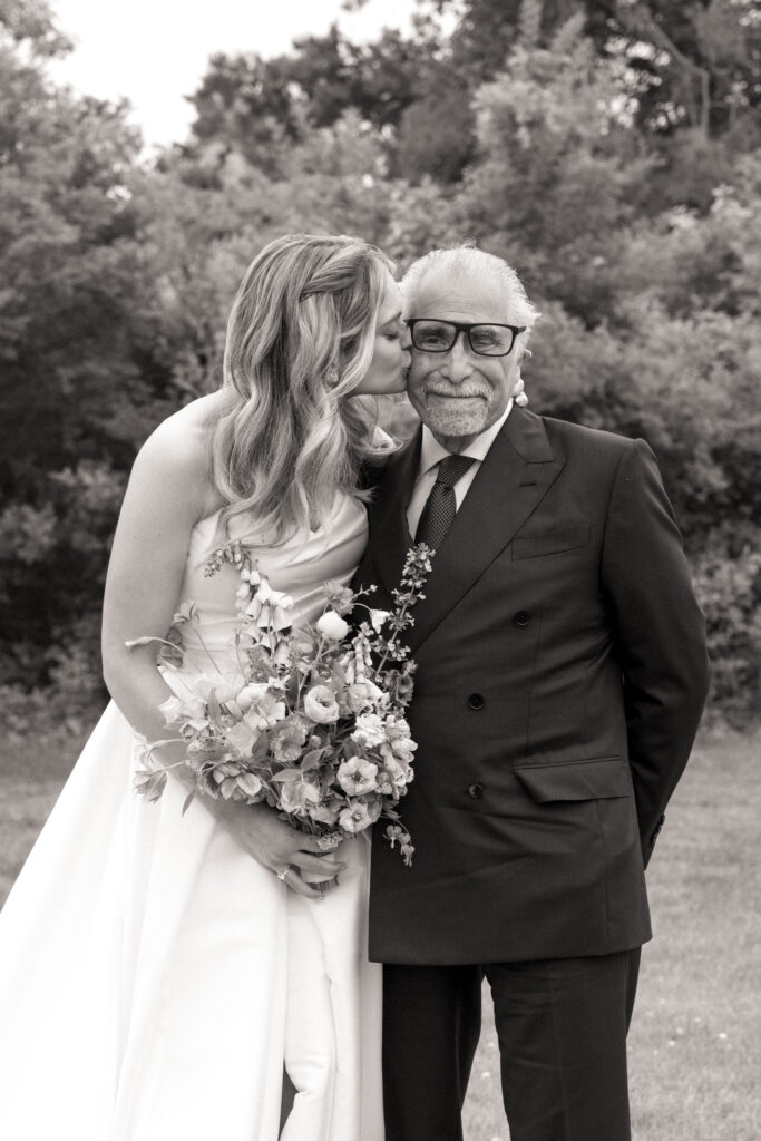 Bride kissing her father’s cheek while holding bouquet, classic black and white Martha's Vineyard film wedding photography