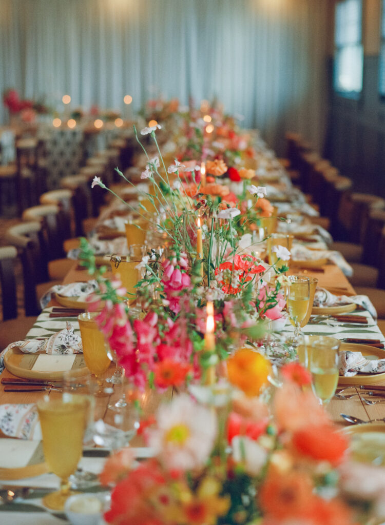 Reception dinner table styled with colorful florals and candles, photographed on film wedding photography in Martha's Vineyard