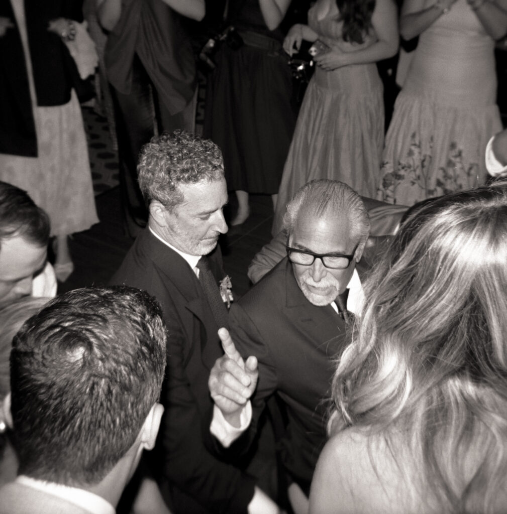 Father of the bride lifted on a chair during the hora at Martha’s Vineyard wedding – black and white candid film photo of the traditional Jewish wedding dance surrounded by guests.