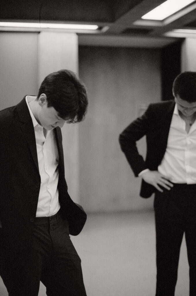 The groom and his groomsman look downward in anticipation of the Boston City Hall elopement