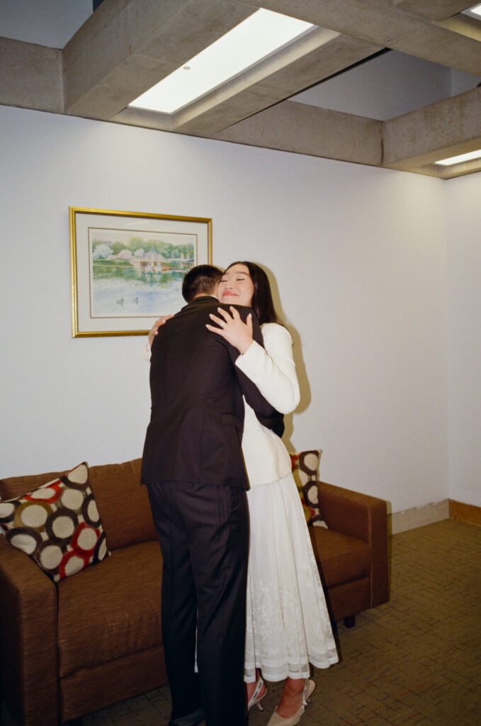 The bride and groom embrace during their ceremony at Boston City   Hall elopement.