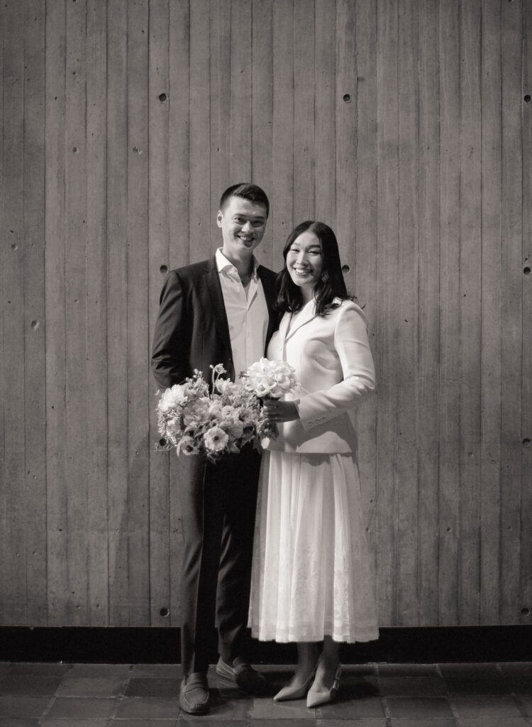 Black and white photograph of bride and groom smiling after their elopement ceremony as Boston City Hall.