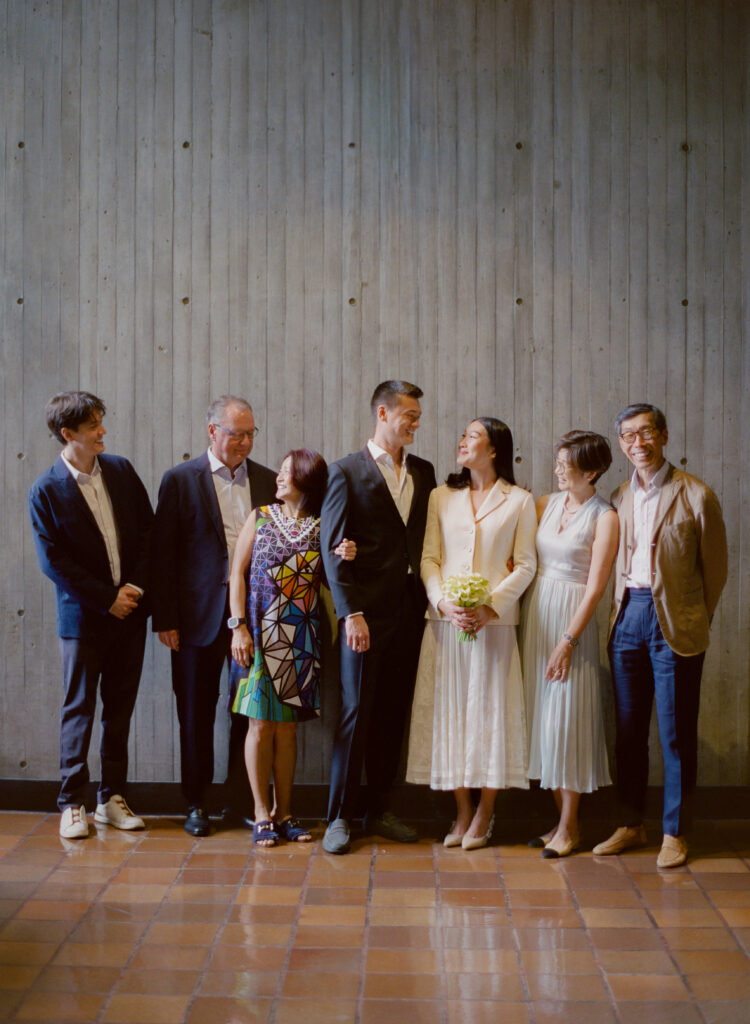 Color film photo of the bride and groom among their families at their Boston City Hall elopement.