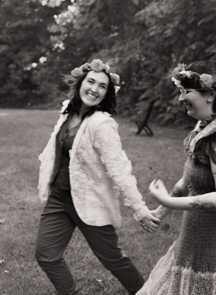 An artsy black and white photograph, catching a couple in motion as they hold hands.