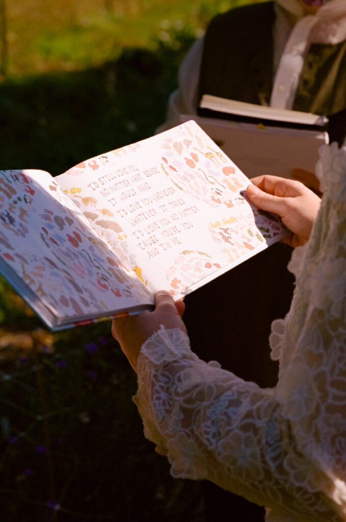 Close-up of bride holding a picture book about love at their wedding altar.