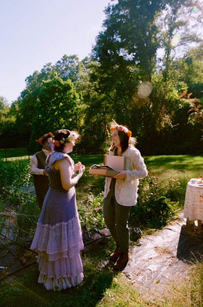 A wide-angle photo of brides at altar revealing a gift box filled with hand-made gifts. 