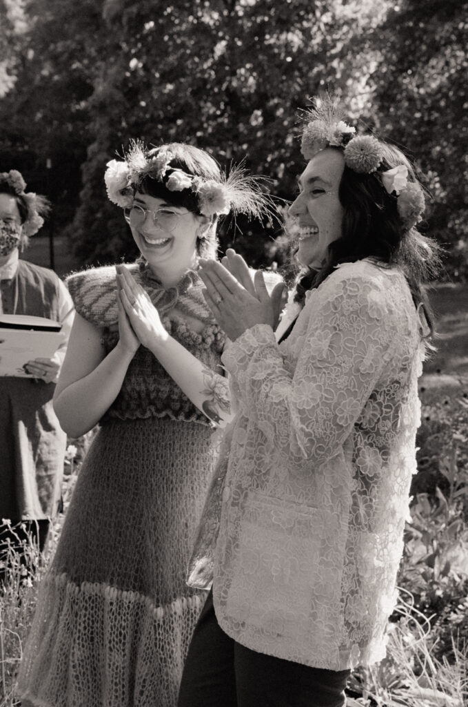Black and white photograph of a couple clapping in appreciation of their wedding ceremony musician.