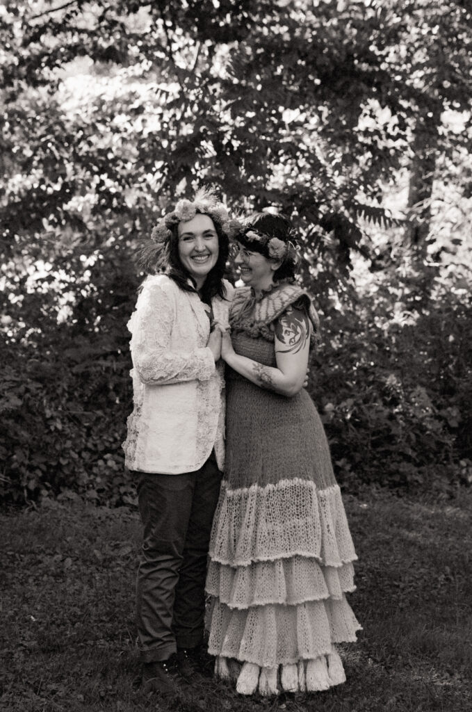 Black and white full-body couples portrait with trees in the background