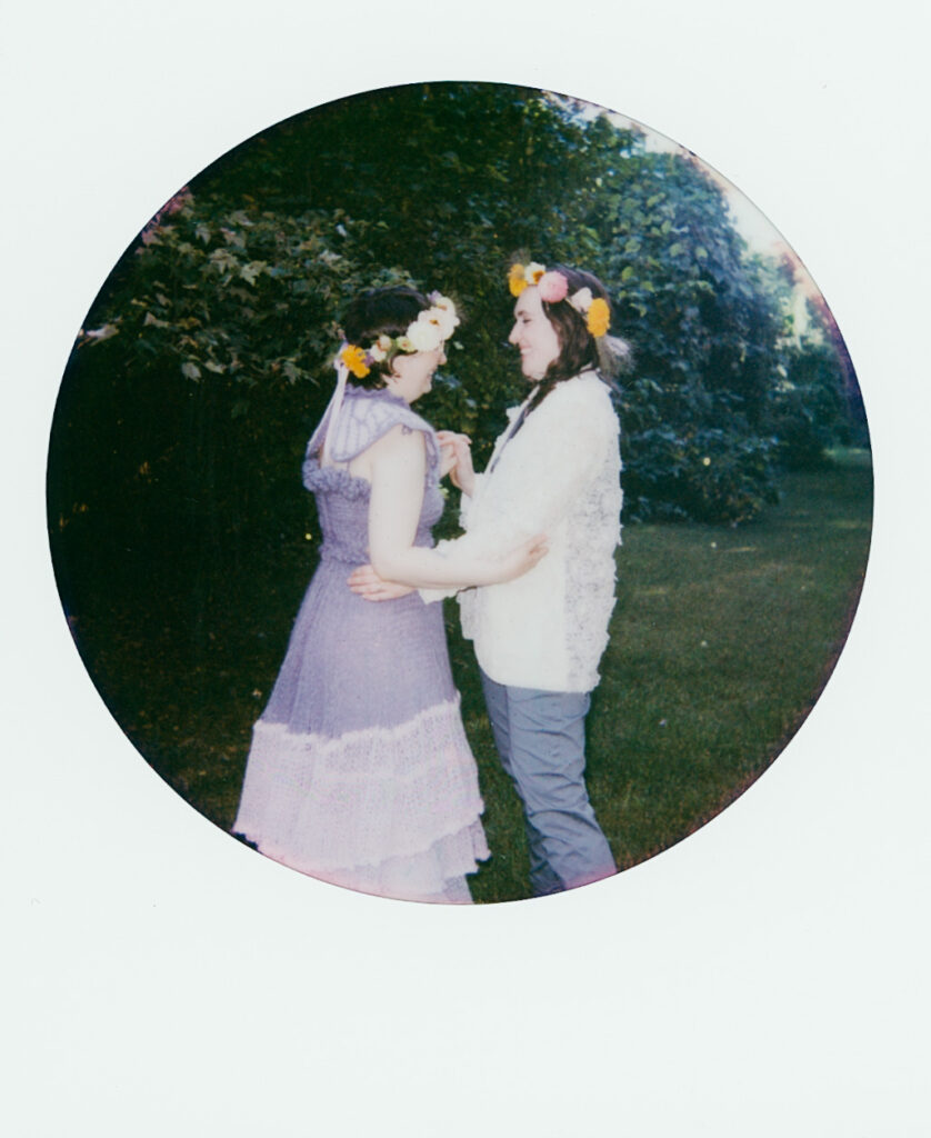 Color polaroid of a couple dancing in a forest.