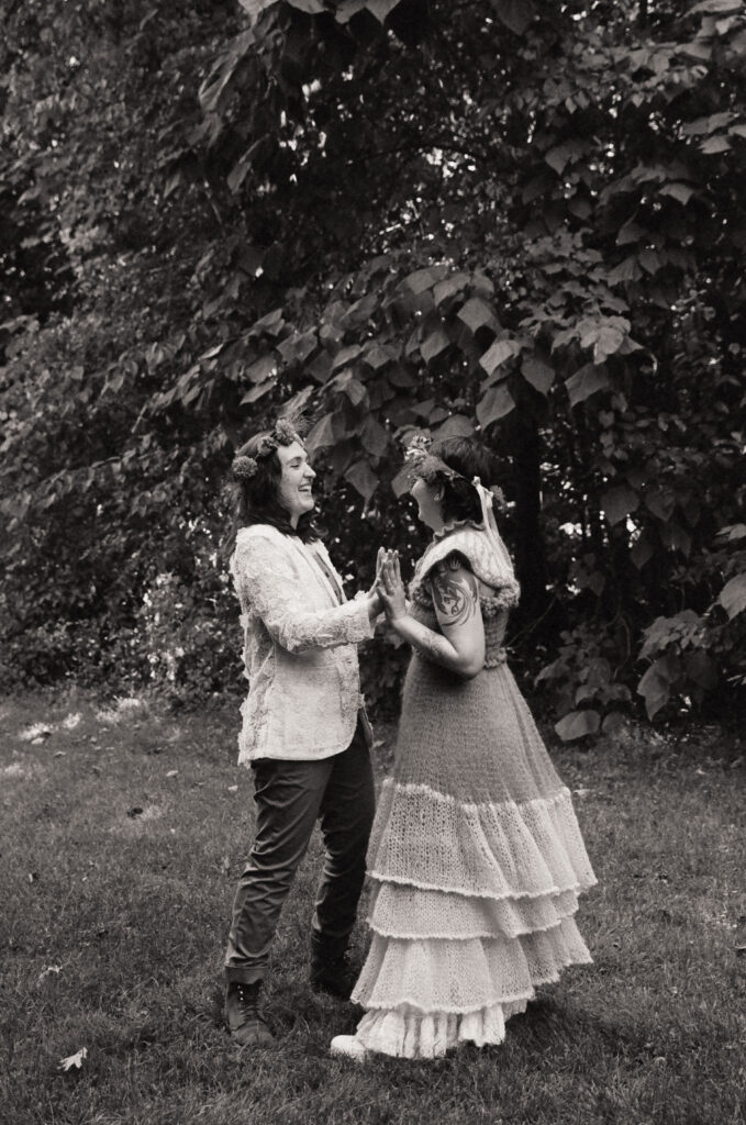 Black and white photograph of brides dancing together. 