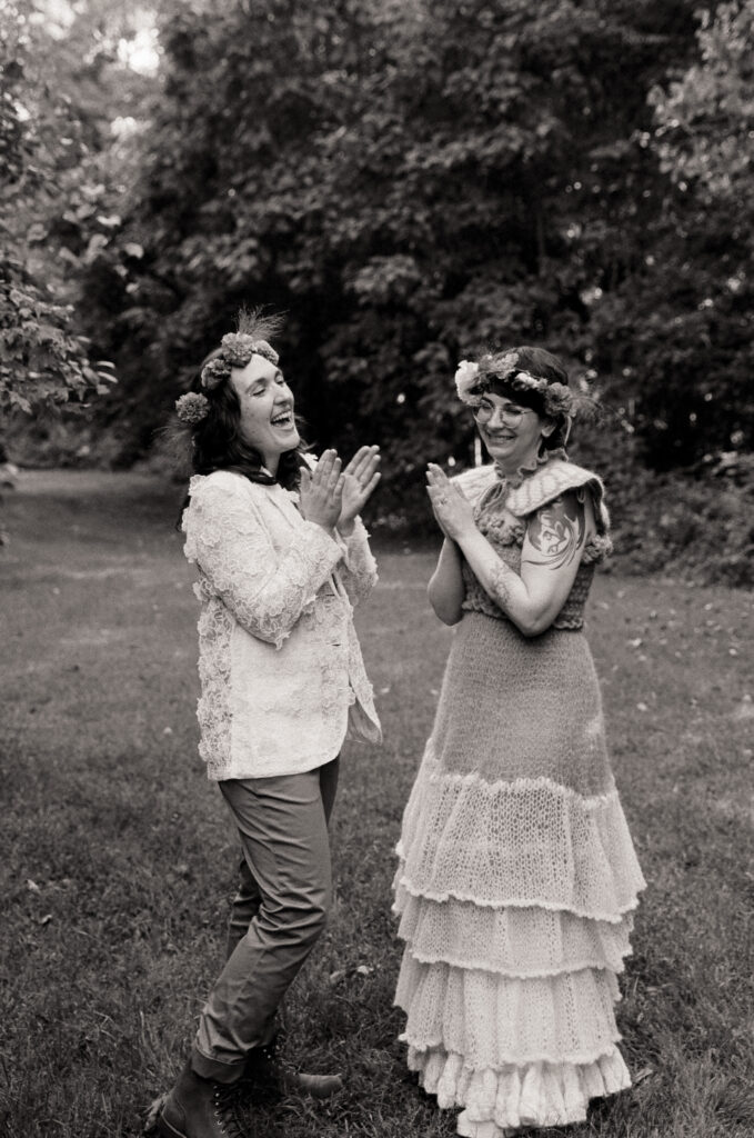 Black and white photograph of couple clapping for the guitarist. 