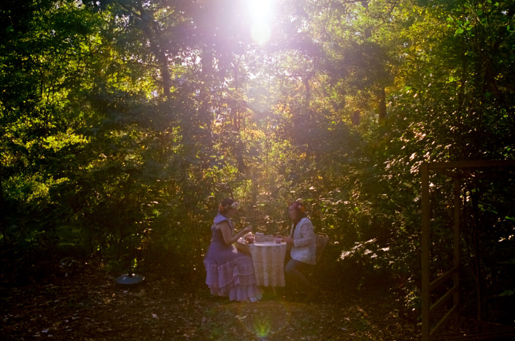 Wide angle photograph of couple sharing a meal amongst the forest. 